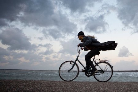 Pays-Bas, Kamperland, femme à vélo contre le vent orageux 
Credit: Profimedia, Alamy